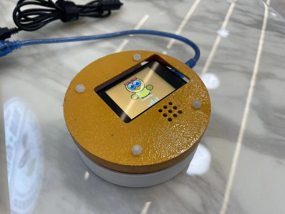 Round gold desktop device with a small screen built at a hackathon