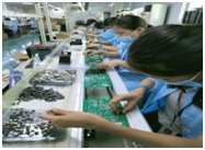 Workers inserting through-hole parts on a DIP line