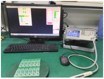 First-article inspection tester next to a panel of boards