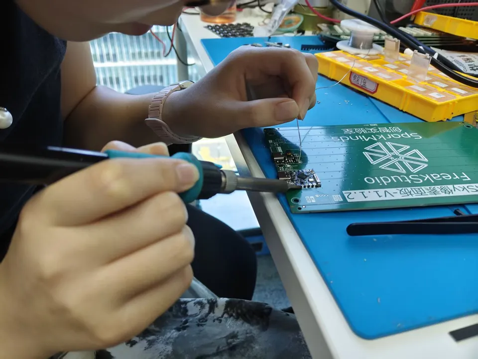 An engineer soldering parts onto a FreakStudio circuit board at our bench