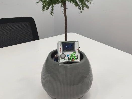 Planter with a small screen device clipped to the pot