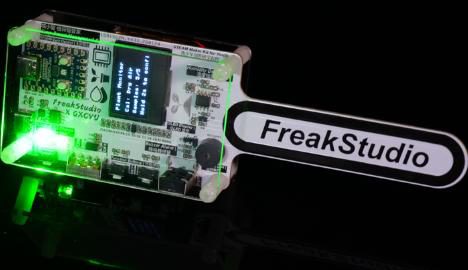 Kit board with an OLED and a long probe printed 'FreakStudio', green LEDs lit
