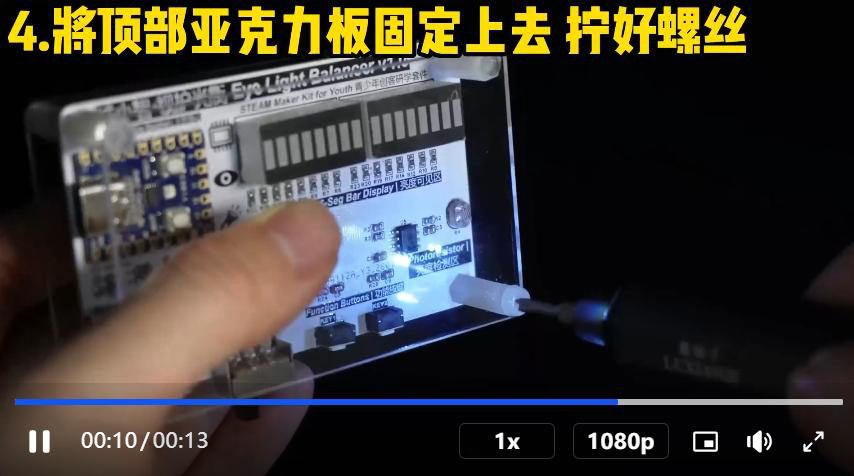 Video frame of a finger fixing the top acrylic plate onto a kit, with a Chinese assembly caption and player controls