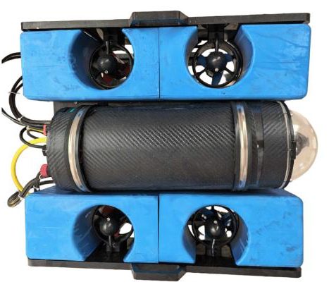 Eight-thruster ROV on a white background seen from above: four blue float blocks with thrusters around a carbon-fibre tube, yellow and black cables at one end