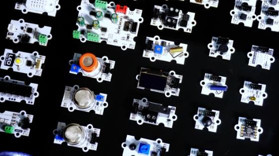 Top view of sensor modules laid out in rows on a black surface, including gas sensors and a small OLED module