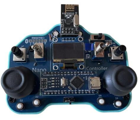 Blue handheld controller board with two joysticks, toggle switches, an OLED screen, a wireless module and 'Nano Controller' silkscreen, in a teal 3D-printed case