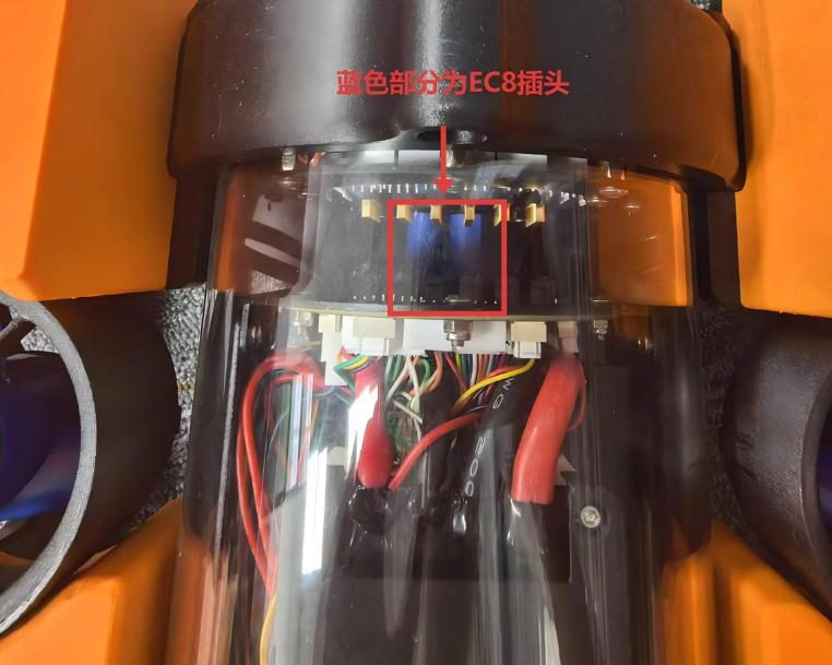 Close-up inside the clear electronics tube between orange shells, wiring and a connector board, with a red box and red Chinese annotation marking the blue EC8 power connectors