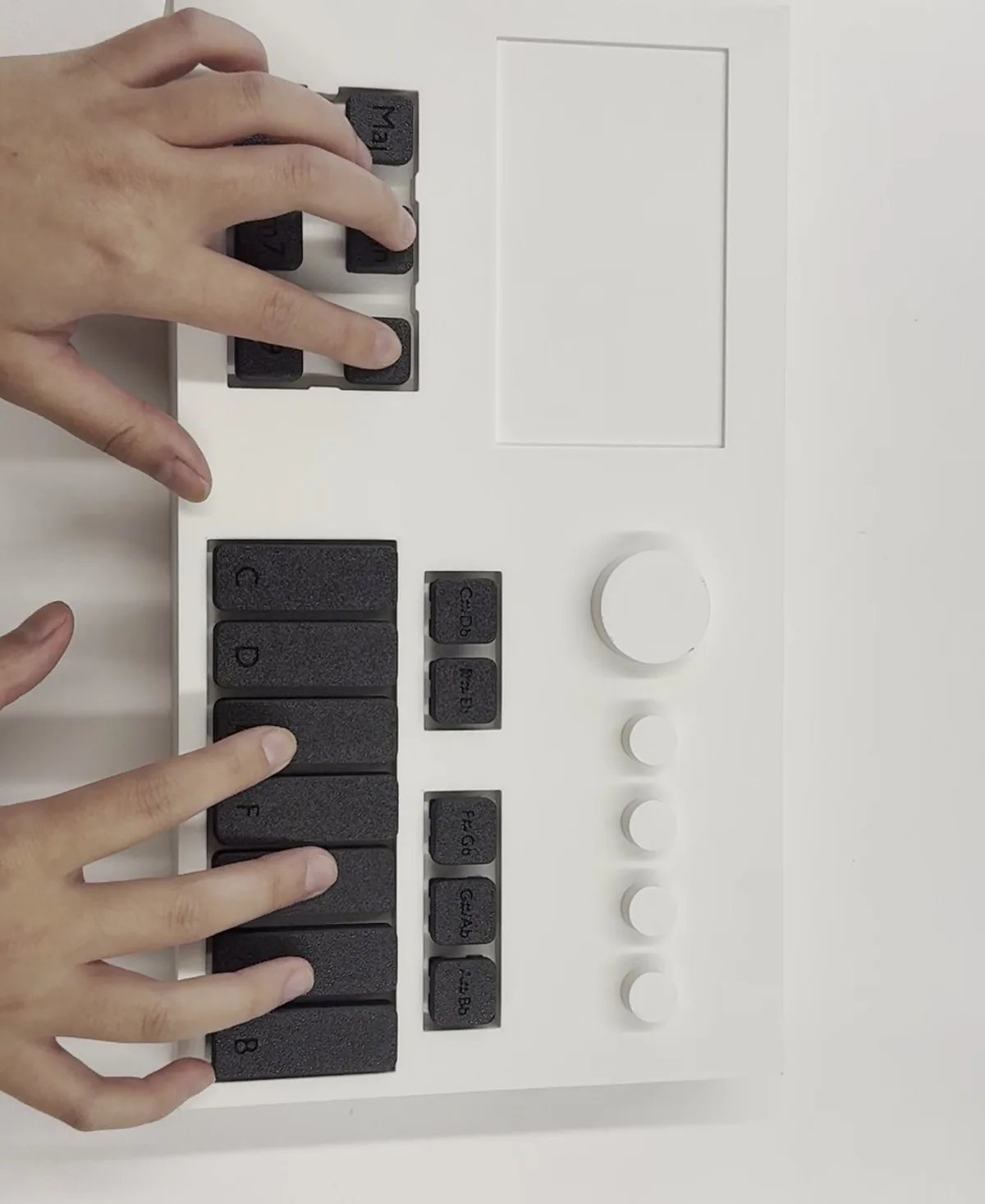 The creator's working prototype of Project Play: a 3D-printed body with keycaps, being played on a desk