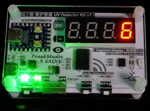Kit board in a clear acrylic case with a red 7-segment display reading 6 and green status LEDs