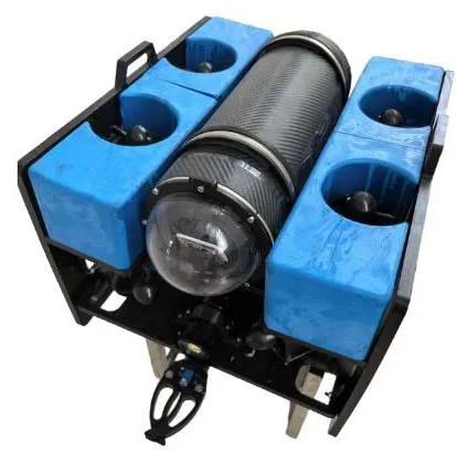 Eight-thruster ROV on a white background, three-quarter front view: blue foam float blocks with vertical thrusters, carbon-fibre pressure tube with front camera dome, black frame and a small gripper underneath