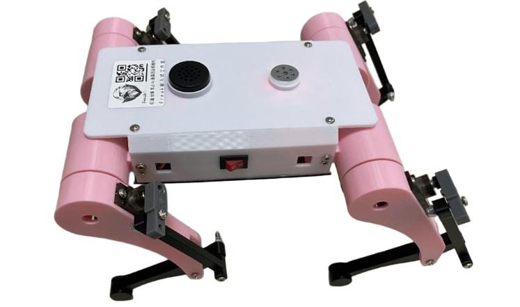 Front-angled view of the pink quadruped showing the power switch, speaker and lid sticker, on white