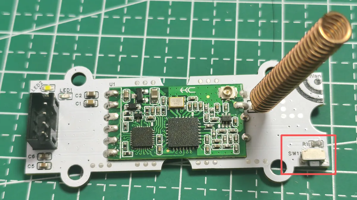 HC-14 radio on a white carrier with a spring antenna fitted and the configuration button outlined in red