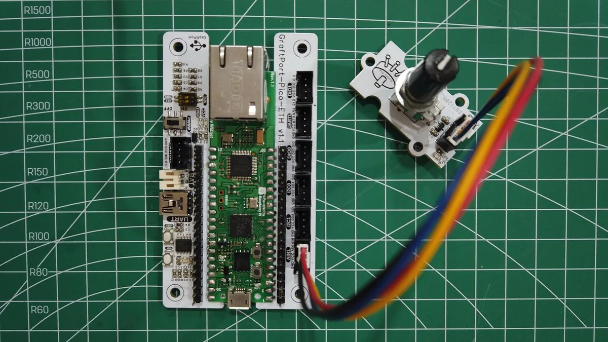 Rotary potentiometer module cabled to a GraftPort-Pico-ETH carrier on a cutting mat