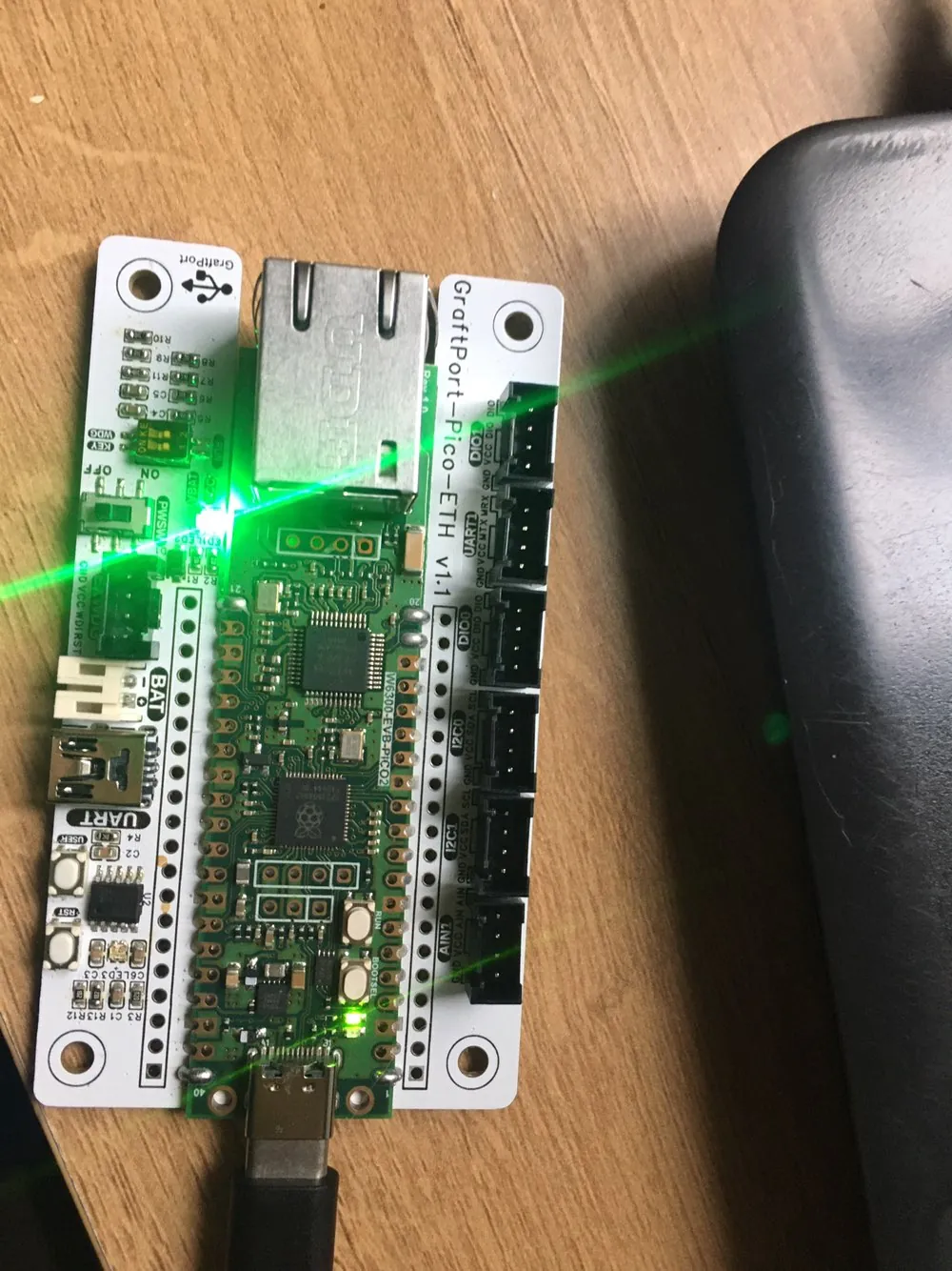WIZnet EVB-Pico2 board on a GraftPort-Pico-ETH carrier, connected by USB-C, with a green LED lit