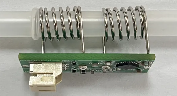 Clear plastic tube passing through two spring electrodes mounted on a small green circuit board