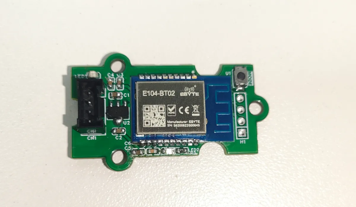 E104-BT02 Bluetooth module on a green carrier board with a four-pin connector, a MODE button and a side header